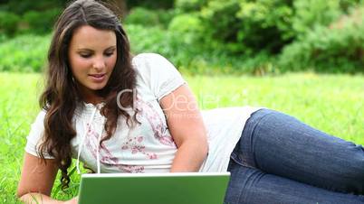 junge Frau mit Laptop im Park