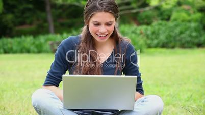junge Frau mit Laptop im Park