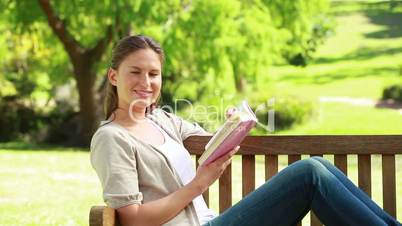 Frau liest Buch in einem Park