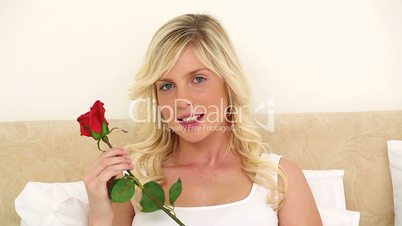 Frau riecht an Rose