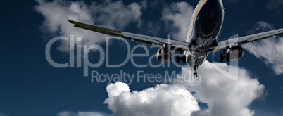 Passenger jet landing against a blue sky with white fluffy cloud