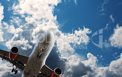 Passenger jet against a blue sky with white fluffy clouds