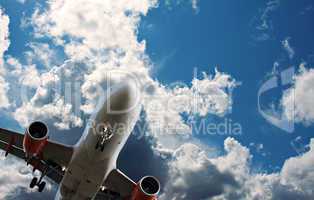 Passenger jet against a blue sky with white fluffy clouds