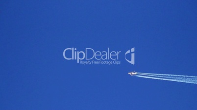 Airplane vapor trails against a clear blue sky 1 slow motion