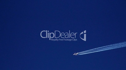 Airplane vapor trails against a clear blue sky 2