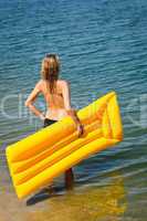 Summer woman hold yellow floating mat