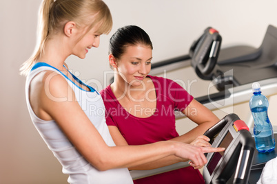 Young female friends chatting in fitness center