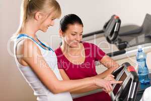 Young female friends chatting in fitness center