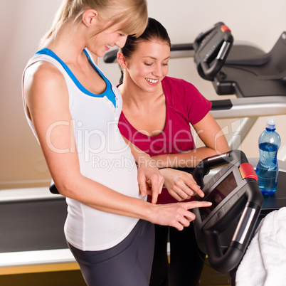 Young female friends chatting in fitness center