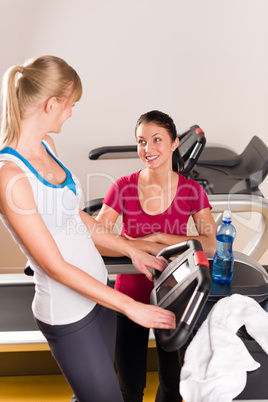 Young female friends chatting in fitness center