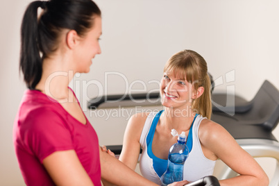 Young female friends chatting in fitness center