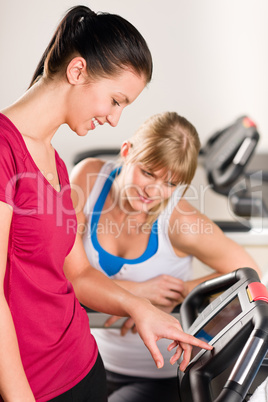 Young women on treadmill giving instructions