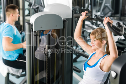 Two people at fitness center exercise machine