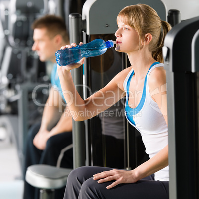 Young woman at gym drink water