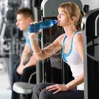 Young woman at gym drink water