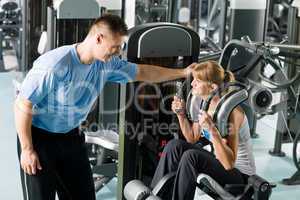 Fitness center young woman exercise with trainer