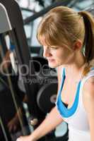 Young woman at fitness center exercise machine