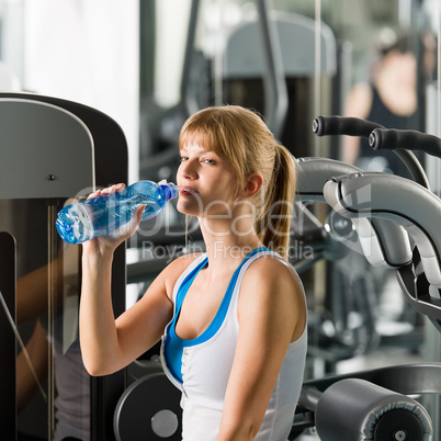 Woman drink water at fitness machine