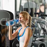 Woman drink water at fitness machine