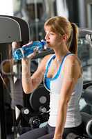 Woman drink water at fitness machine