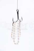 jewelry made of pearls hanging on fishing hook