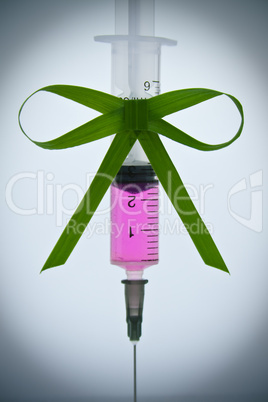 syringe pink liquid with ribbon of grass