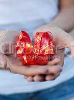 young woman holds a gift bow in hands