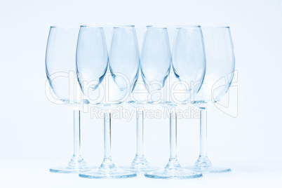 Empty wine glasses stand symmetrically on white