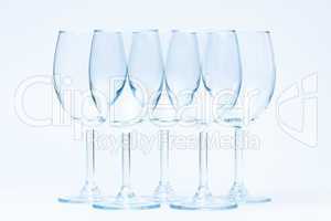 Empty wine glasses stand symmetrically on white