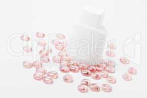 white container for cosmetics on pink glass stones