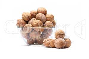Walnuts lie in a glass bowl isolated on white