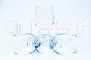 Wine glasses stand and lie symmetrically on white