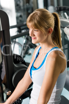 Young woman at fitness center exercise machine