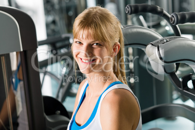 Smiling woman at fitness center exercise machine