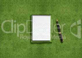 Blank notebook on grass