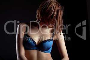 Young woman in blue lingerie hide face by hairs