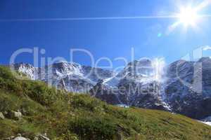 green grass, glaciers, peaks and sun