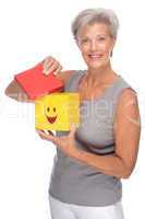 glückliche und aktive Seniorin mit einer Smiley-Box