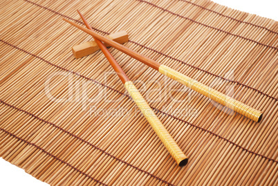 Chopsticks on brown bamboo matting background