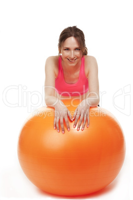 junge frau stützt sich auf orangenem fitness ball