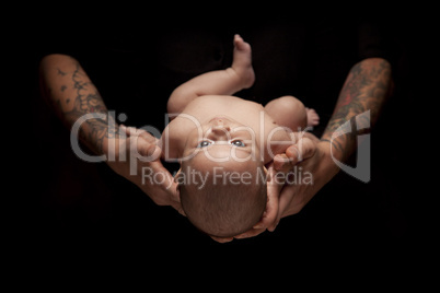 Hands of Father and Mother Hold Newborn Baby on Black