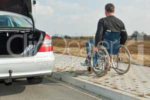 Man in a wheelchair next to his car