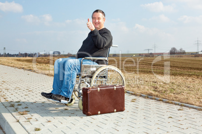 Man with suitcase wheelchair and walk on the road