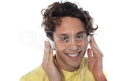 Casual young man listening music with headphones