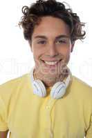Guy with headsets around his neck smiling at you