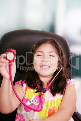 Cute little girl is playing doctor with stethoscope, isolated ov