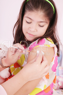 child receiving an injection by the hands of a pediatrician