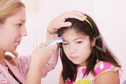 Portrait of a sick child being checked with a thermometer by a d