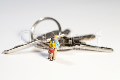 Miniatur Paar in inniger Umarmung mit Schlüssel im Hintergrund