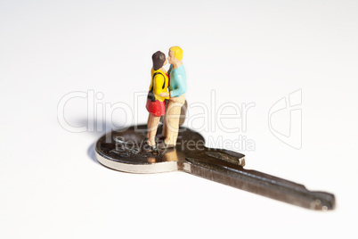 Miniatur Paar in inniger Umarmung mit Schlüssel im Hintergrund